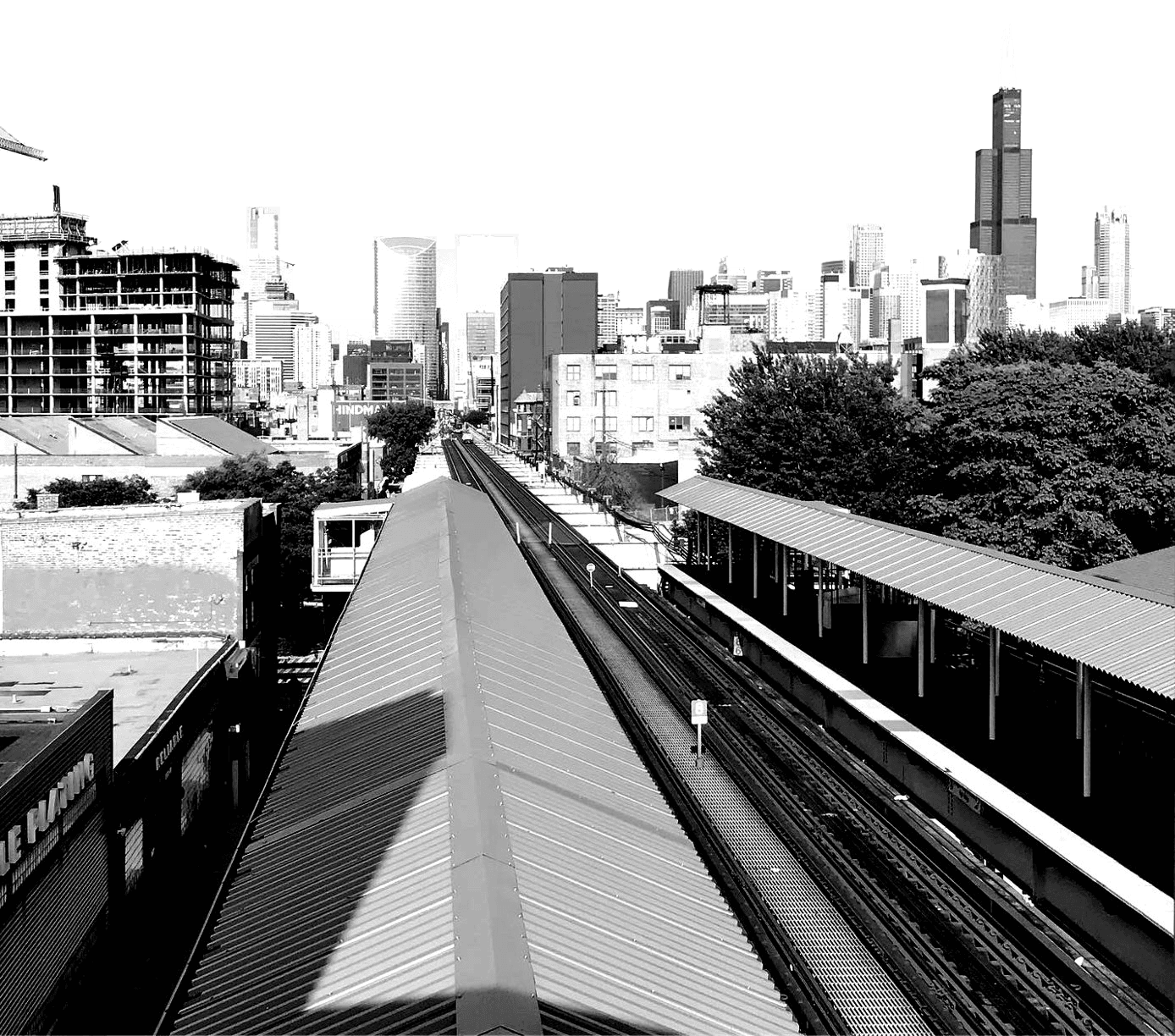 Chicago's skyline over the elevated train tracks, in black and white